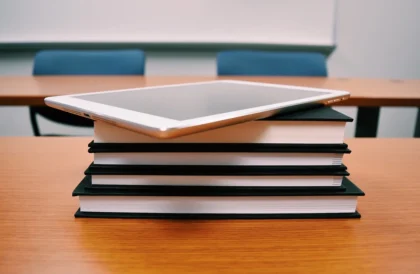 Imagem de tablet em cima de pilha de livros em cima de mesa na sala de aula